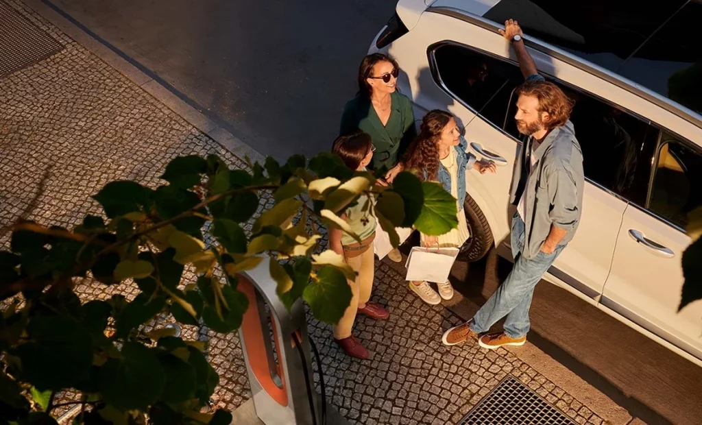 Familj pratar bredvid en vit Santa fe plugin Hybrid