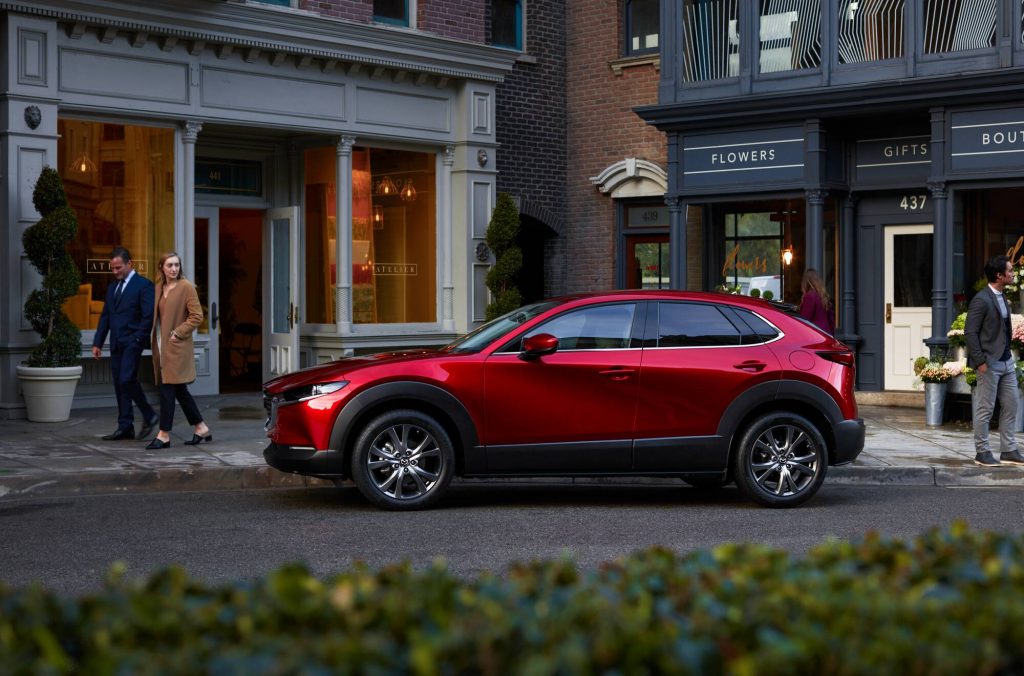 Röd Mazda CX-30 med människor runtomkring