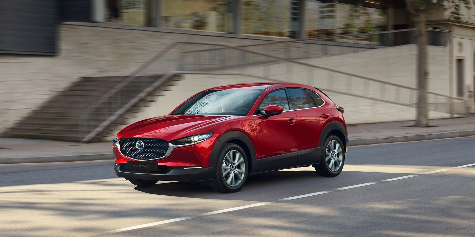 Röd Mazda CX-30 kör på väg