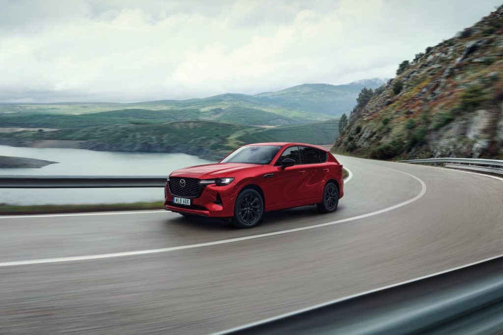 Röd Mazda CX-60 som åker längs en fin väg