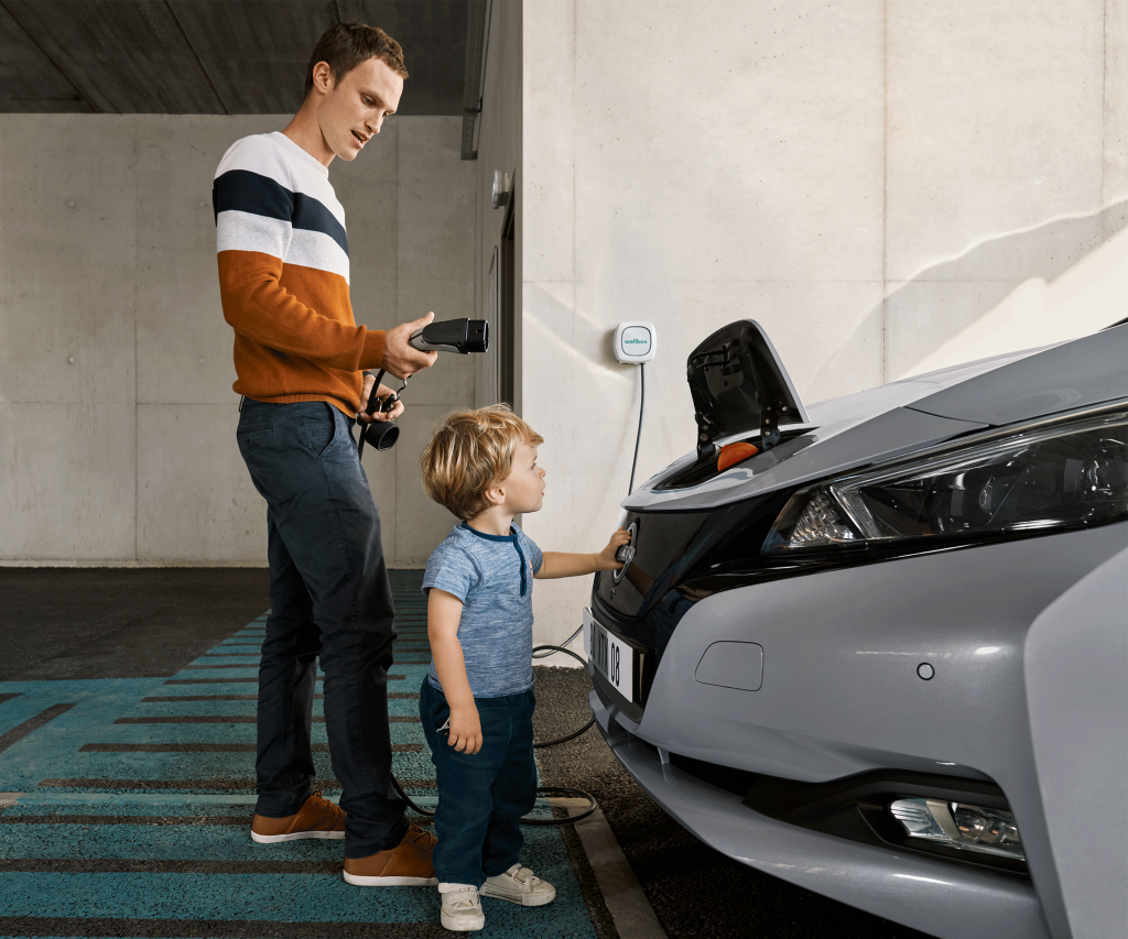Far och son laddar grå Nissan Leaf 