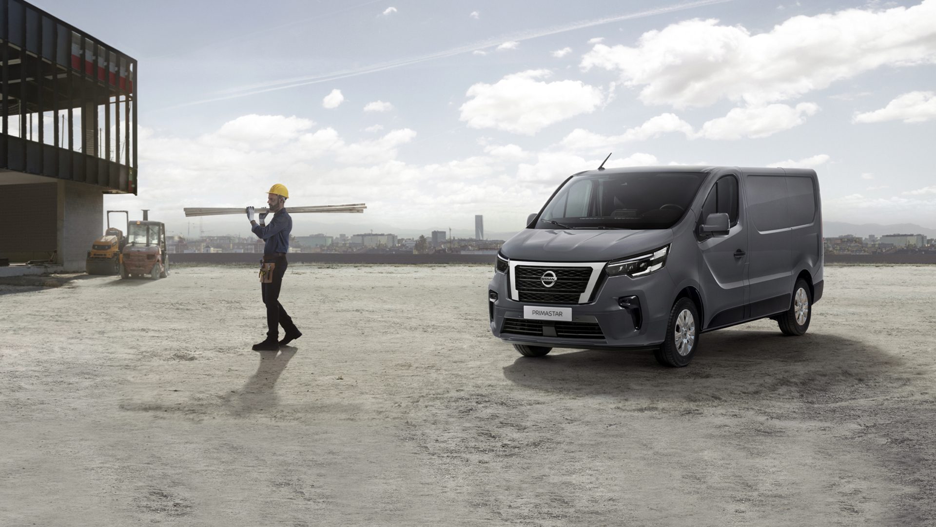 Grå Nissan Primastar med man som bär på plankor brevid