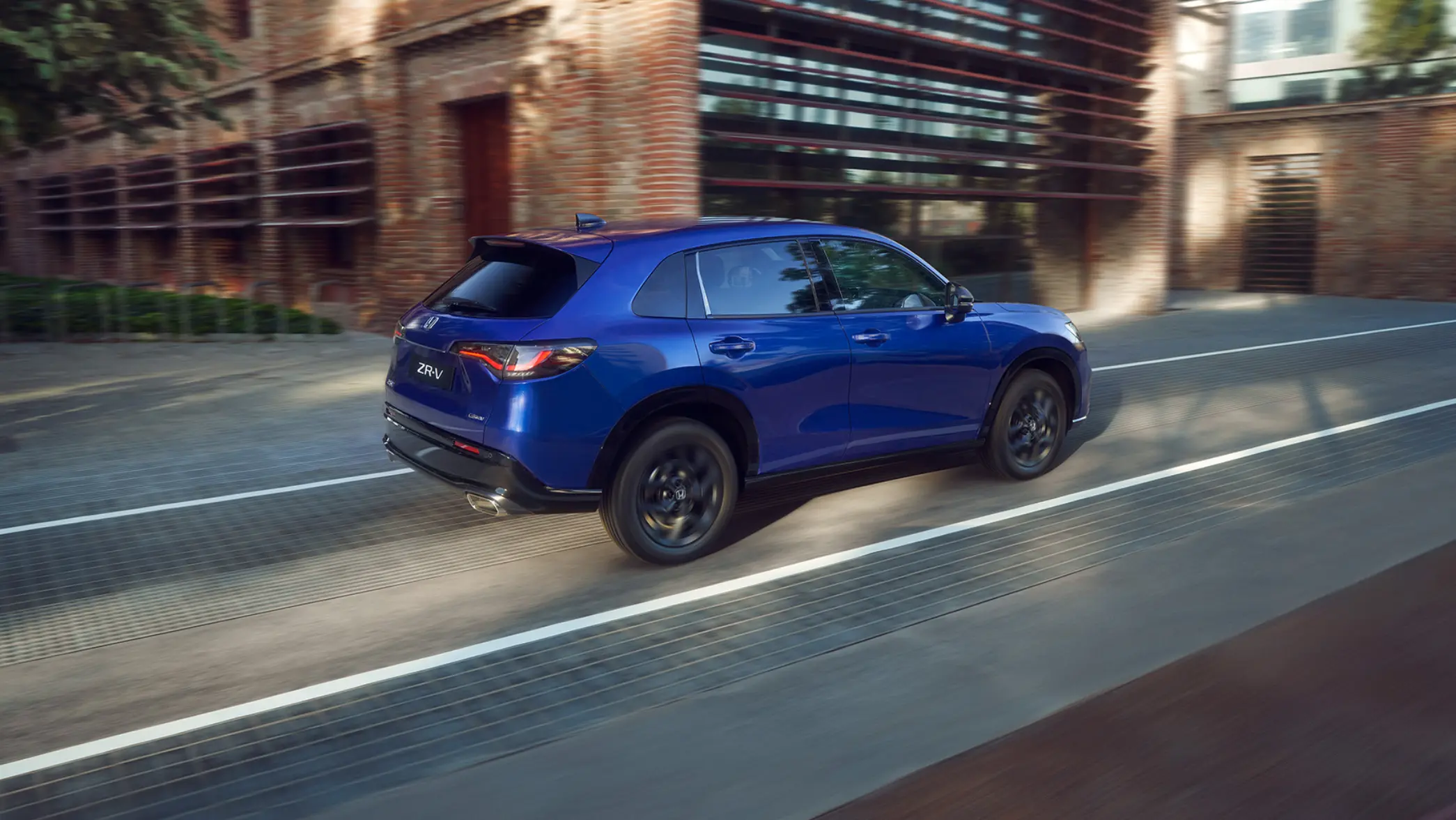 Blå Honda ZR-V kör längs stadsgata