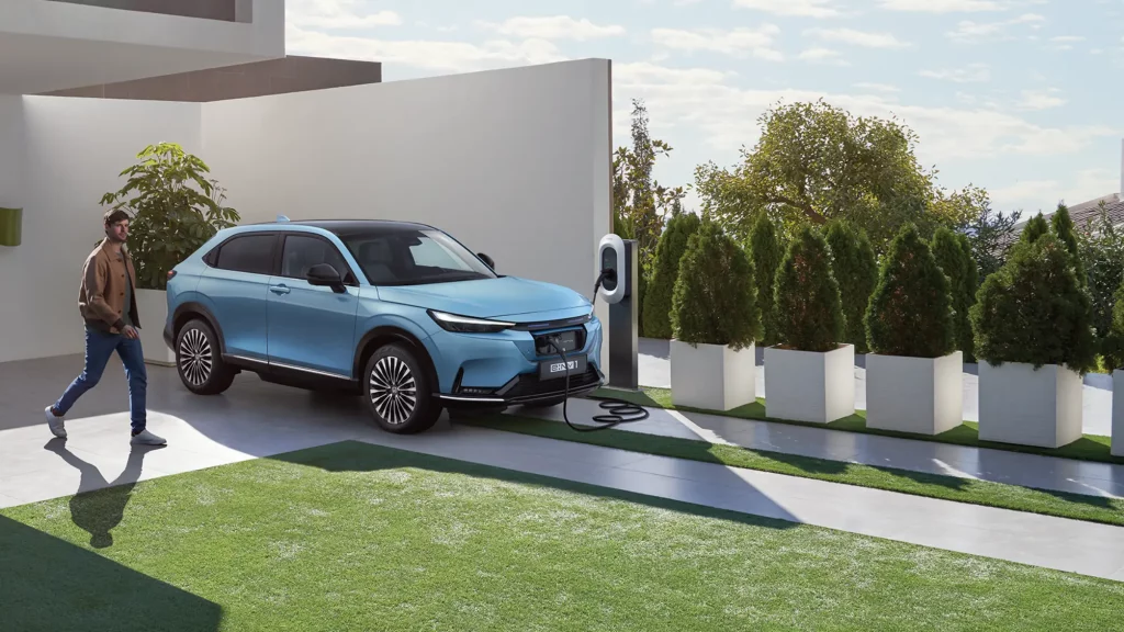 Honda e:Ny1 parkerad och laddar på uppfart till villa