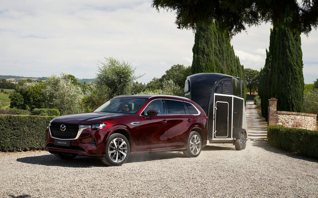 Mazda CX-80 i färgen ARTISAN red med tillkopplad hästtransport