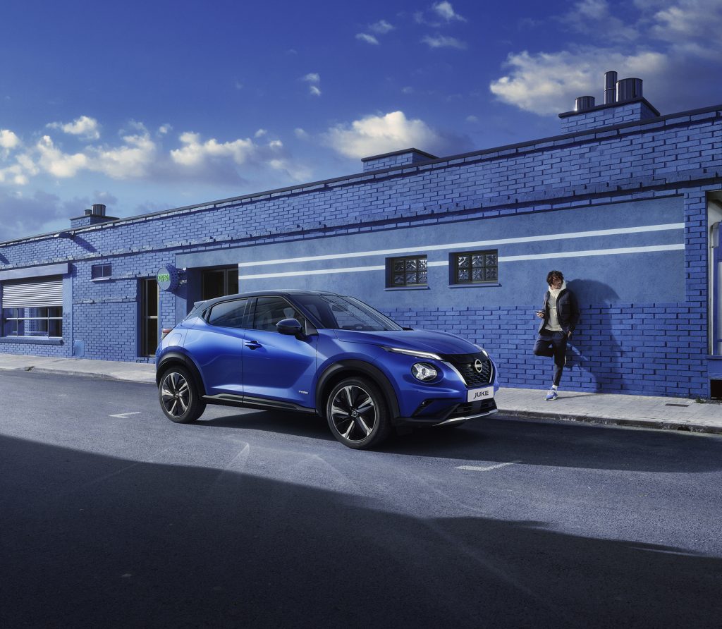 Nissan Juke exteriörbild blå med blå tegelvägg i bakgrunden