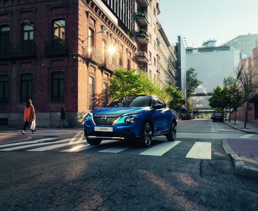 Nissan Juke i blå färg kör över ett övergångsställe i en korsning
