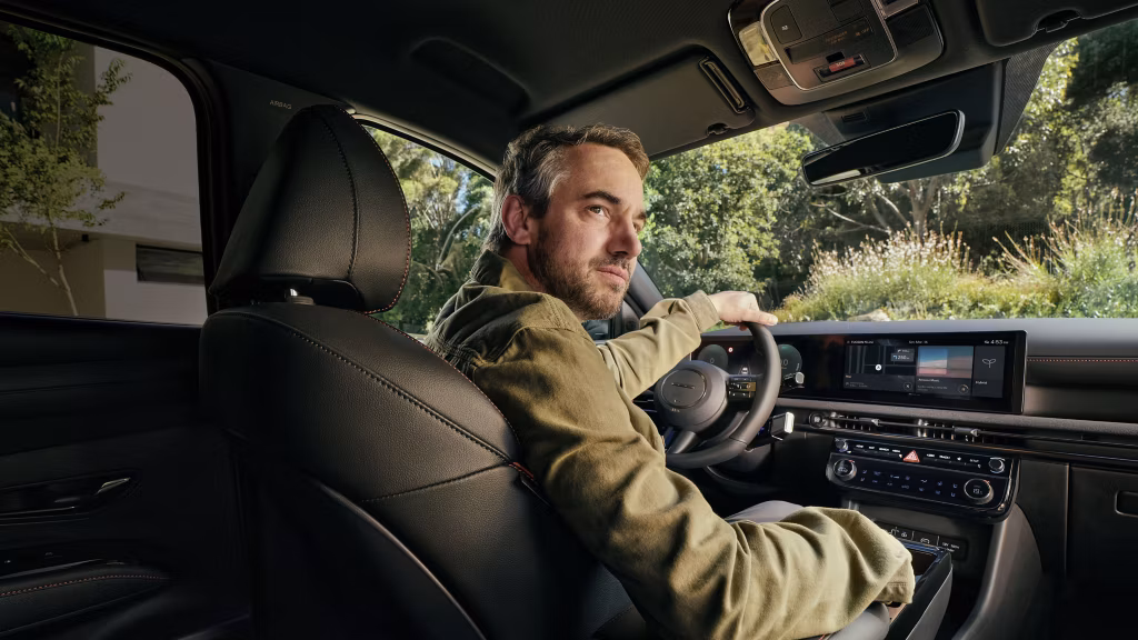 Nya Hyundai Tucson interiörbild med en medelålders man vid ratten.